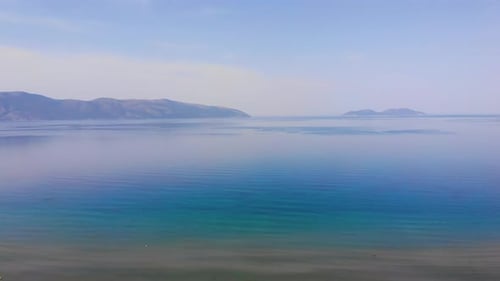 Meer, Strand, Sonnenuntergänge, schöner Himmel, Drohnen-Kamera aus der Insel am Horizont.
Albanien