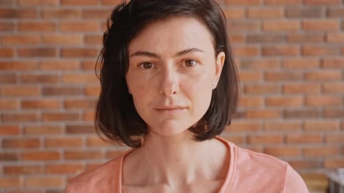 Woman Smiling in Front of Brick Wall Close Up