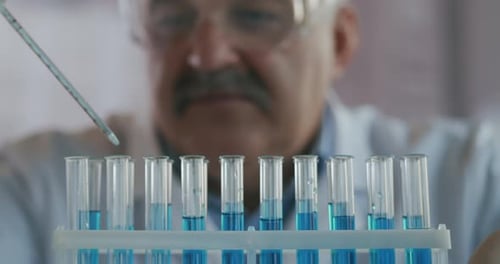 Close Up Scientist Adding Liquid to Test Tubes