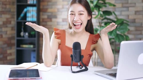 Young Woman Vlogging at Desk with Microphone