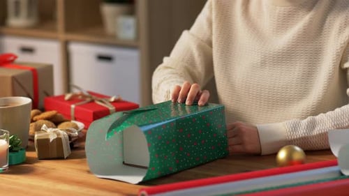 Woman Wrapping Christmas Gift at Wooden Table