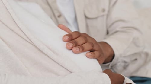 Gros plan Mains d'un homme noir caressant le ventre d'une femme enceinte La charmante épouse porte des vêtements blancs