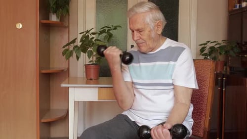 Senior Man Exercising Indoors with Dumbbells