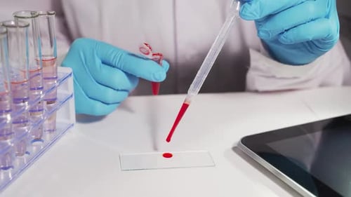 Scientist Drops Liquid on Slide, Uses Tablet