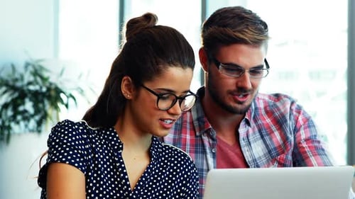 Colleagues Working Together at a Laptop in Office