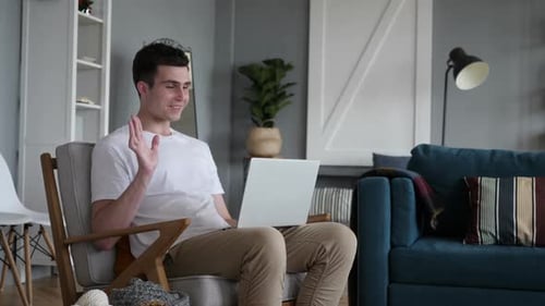 Young Adult Video Chatting With Laptop in Living Room