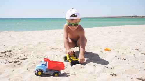 Tanned Boy Playing with Cars on the Beach, Plastic Toy Car, Excavator