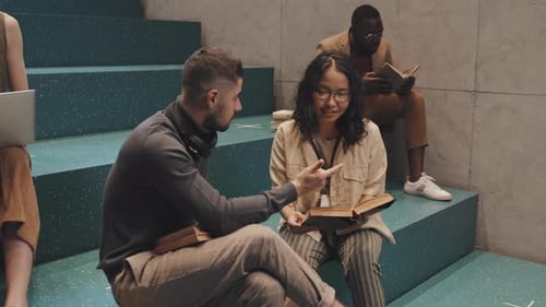 Des étudiants universitaires multiethniques étudient ensemble dans les escaliers