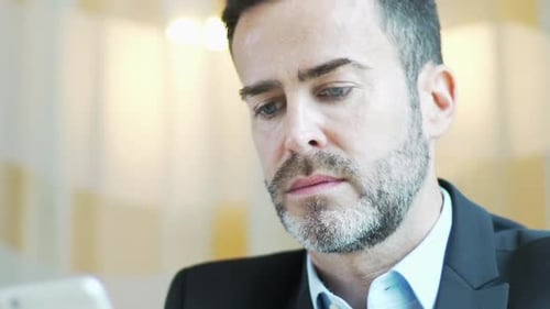 Man Smiling, Laughing at Smartphone Device, Close Up