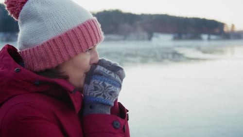 a Woman in Warm Clothes and Mittens at Frosty Morning on the Lake