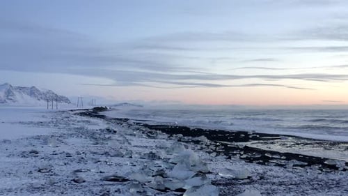 VUE AÉRIENNE : Survol de Diamond Beach, Black Beach en Islande en hiver : neige, glace, vagues, eau