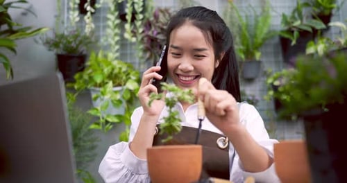 Femme parlant au téléphone de la vente d'une usine avec un client