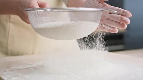 Close up video of sifting flour in domestic kitchen. Shot with RED helium camera in 8K