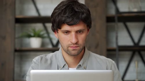 Happy Winner. Young Excited Man Using Laptop Computer While Sitting on Sofa.