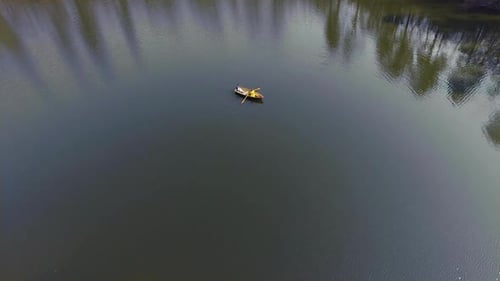 Two People in the Small Boat Boating Across a Beautiful Wide Reflective Lake or River. Active
