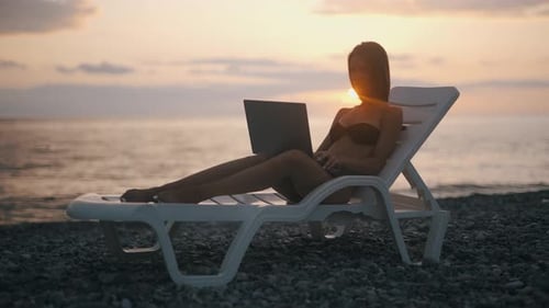 Eine Freelancerin arbeitet am Laptop in Seenähe