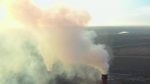 Industriezone mit einem großen rot-weißen Rohr dicker weißer Rauch wird aus dem Fabrikrohr gegossen