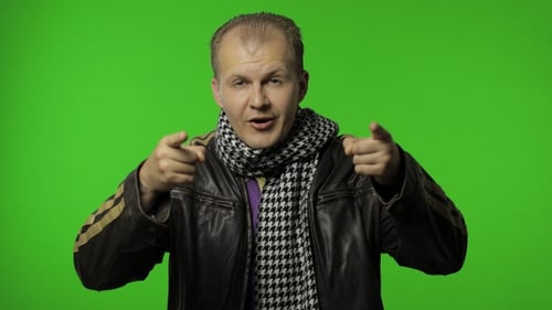 Hübscher Positive Rocker Man in brauner Jeansjacke zeigt mit dem Finger auf die Kamera, Chroma Key