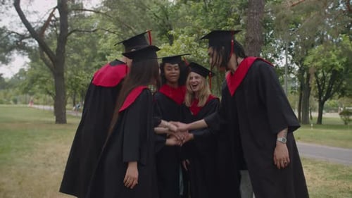 Excited Graduates Celebrate Together in a Green Park