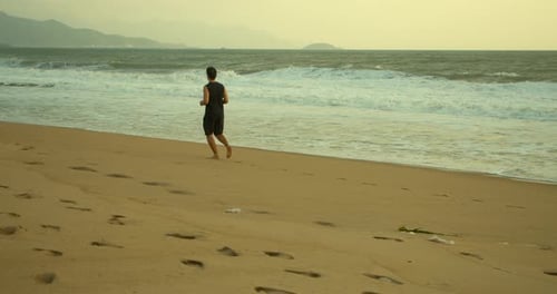 Young Caucasin Man Are Exercising with Outdoor Running with a Beautiful Sea Background