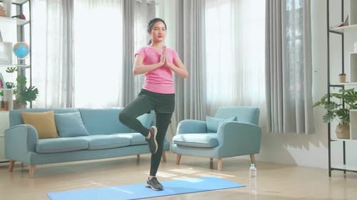 Woman Doing Tree Pose Yoga In Living Room