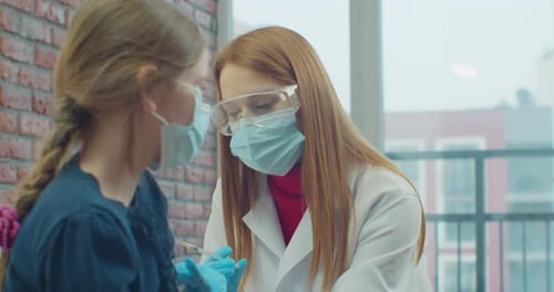Doctor Giving Child a Vaccine in Clinic