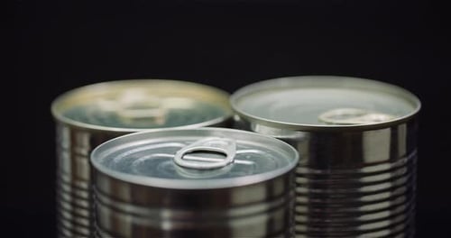Close Up of Three Metal Cans on Black