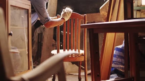 Carpenter working on woodworking machines in carpentry shop