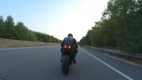 Biker is Accelerating at Motorcycle on Empty Country Road