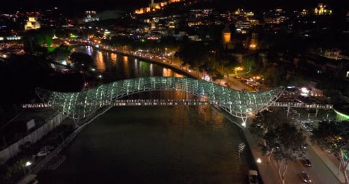 Night aerial view of Bridge of Peace and beautiful cityscape in the center of Tbilisi, Georgia 2022