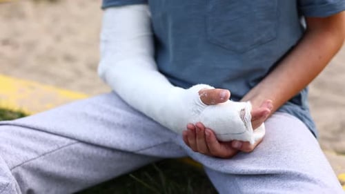 der Arm eines Kindes ist gebrochen. kleiner Junge mit einer gebrochenen Extremität im Freien. Frakturverletzung im Sommer