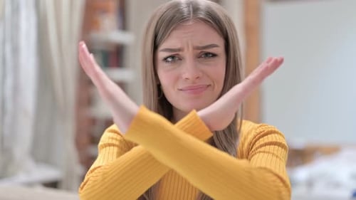 Young Woman Gesturing Rejection With Crossed Arms