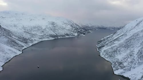 Fjord umgeben von schneebedeckten Bergen, Tromsø, Norwegen
