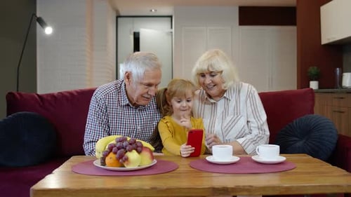 Girl and Grandparents Enjoying Mobile Phone Content