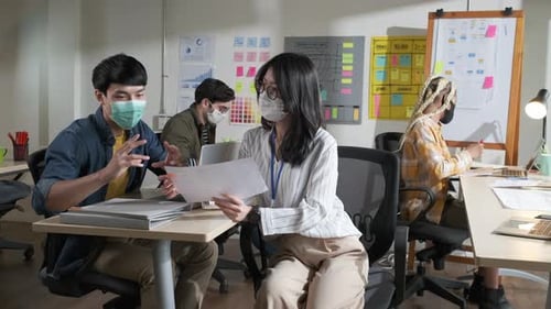 Asian creative business team working at office after lockdown with protective prevention face mask.