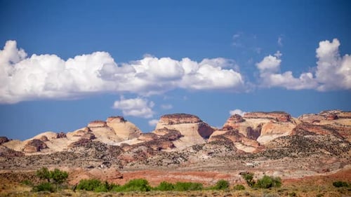 Time lapse of clouds moving across the sky over desert cliffs
