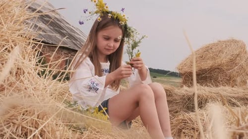 Girl Making Flower Bouquet in Hay Bales