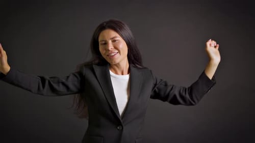 Cheerful Woman Dancing in Black Business Suit