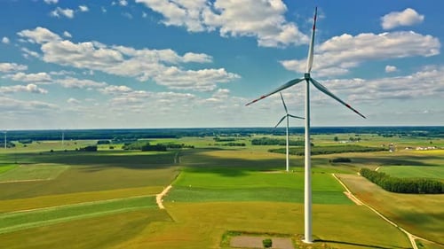 Windturbinen und grüne Wiese am Sommertag
