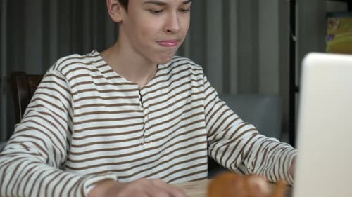 Teen Using Laptop at Desk Indoors