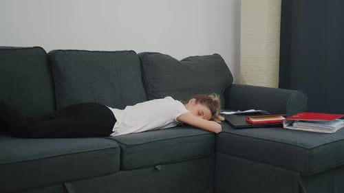 Woman Sleeping on Couch with Laptop and Folders