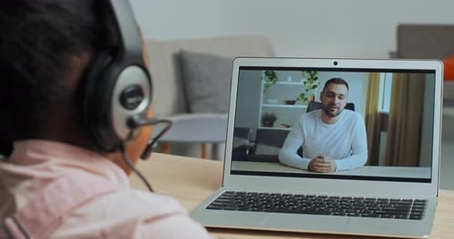 Online Male Teacher Communicating with Teen Afro American Girl School Student By Webcam Conference