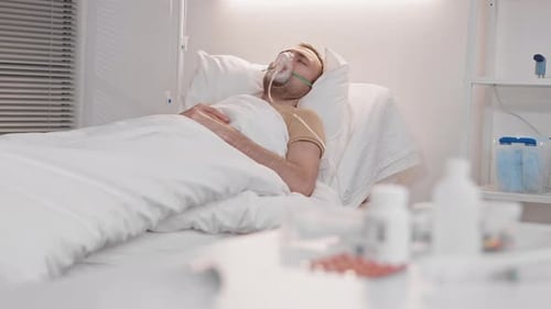 Sick Man lying in Hospital Ward