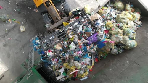 Aerial View of Trash Sorting Facility Garbage Crusher Being Loaded by a Bulldozer