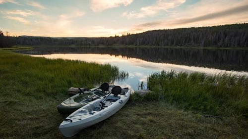 Time lapse of two kayaks lying by lake at sunset