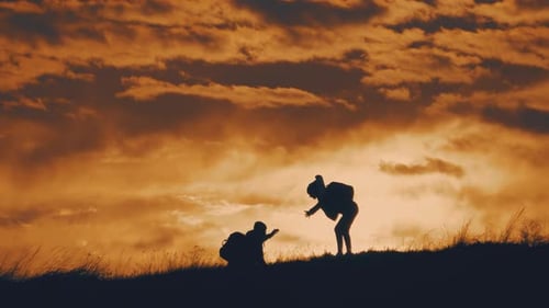 Silhouette of the Team on the Peak of Mountain. Sport and Active Life of People Man and Girl