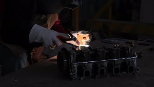 Professional men wearing welding mask and gloves work in home workshop with arc welding and argon.