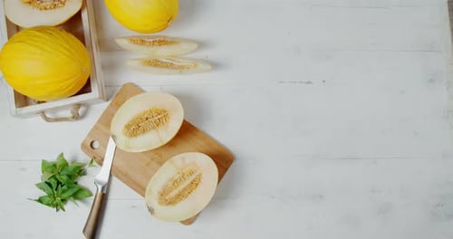 La
moitié du melon tourne sur une planche à découper.