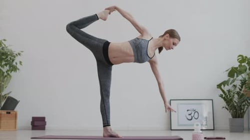 Woman Doing Yoga Half Moon Pose on Mat