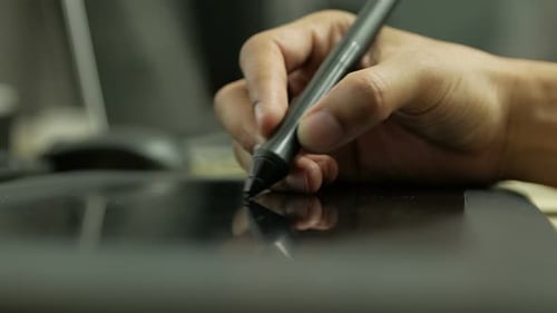 Hand Using Stylus on Drawing Tablet